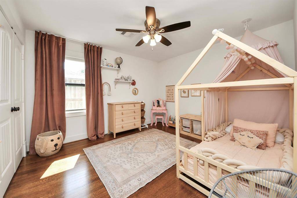 Cozy guest bedroom with elegant hardwood floors, and ample natural light. There are blackout shades in both of the secondary bedrooms