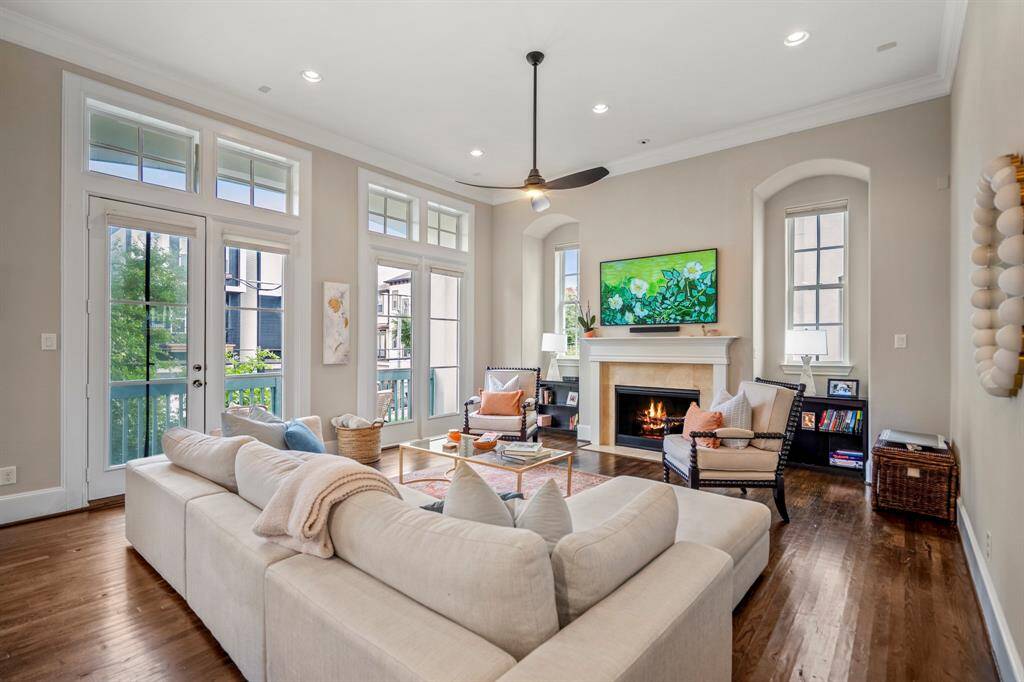 Soaring ceilings, a cozy fireplace, and walls of windows fill this living space with warmth and natural light.