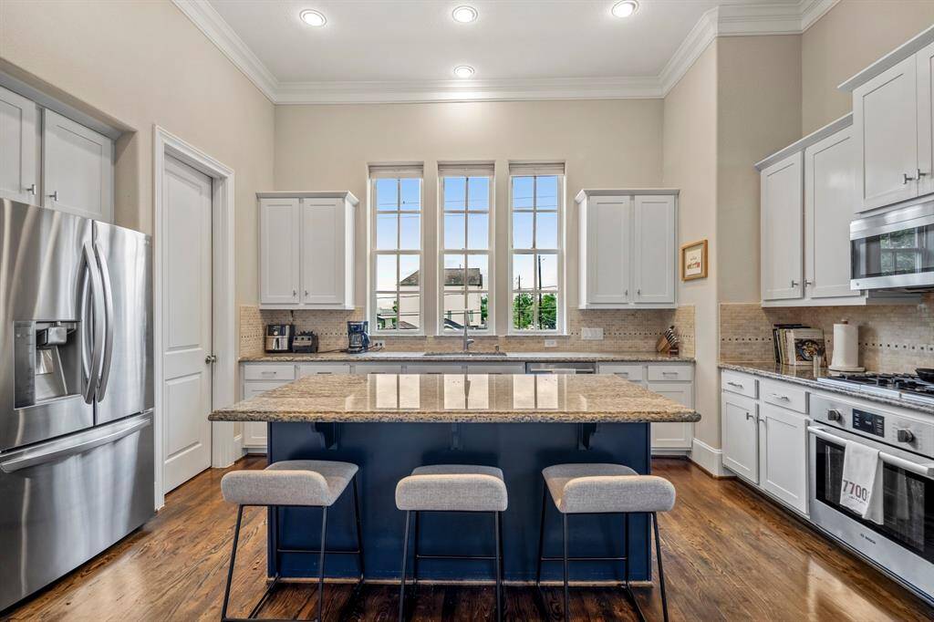 The chef’s kitchen features granite counters, Bosch appliances, and an oversized island made for entertaining.