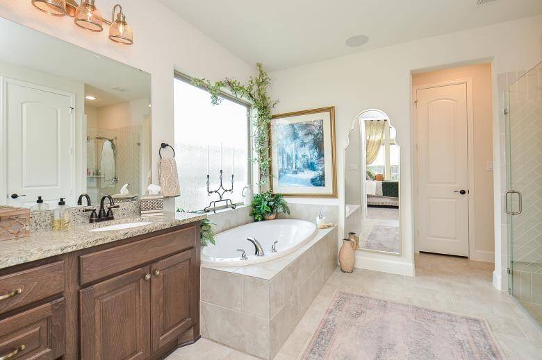 Indulge in Luxury with this Stunning En-Suite Bathroom, Featuring Separate Dual Sinks, Seamless Glass Shower, and a Relaxing Garden Tub.