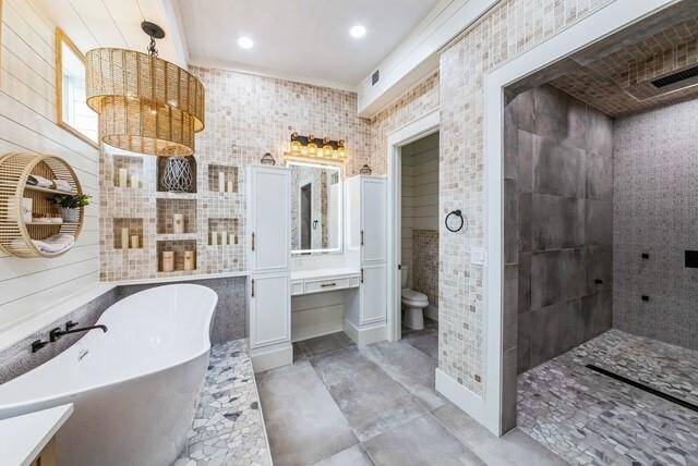 Huge walk-in shower with rainhead, body sprays, and a hand-held sprayer with a linear drain