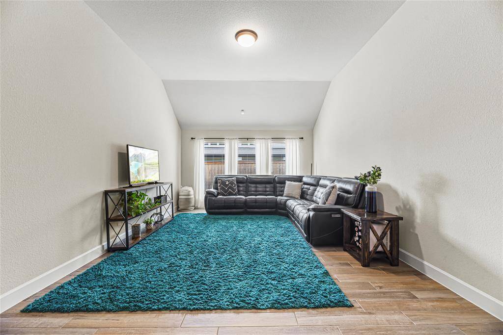 Spacious and serene primary bedroom featuring a tray ceiling and a wall of windows that flood the space with natural light while offering peaceful backyard views.