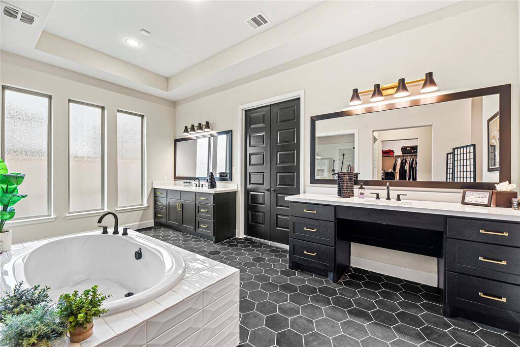 You will love the abundance of soft-close cabinets in this bathroom. And check out the gorgeous tile surrounding the bathtub.