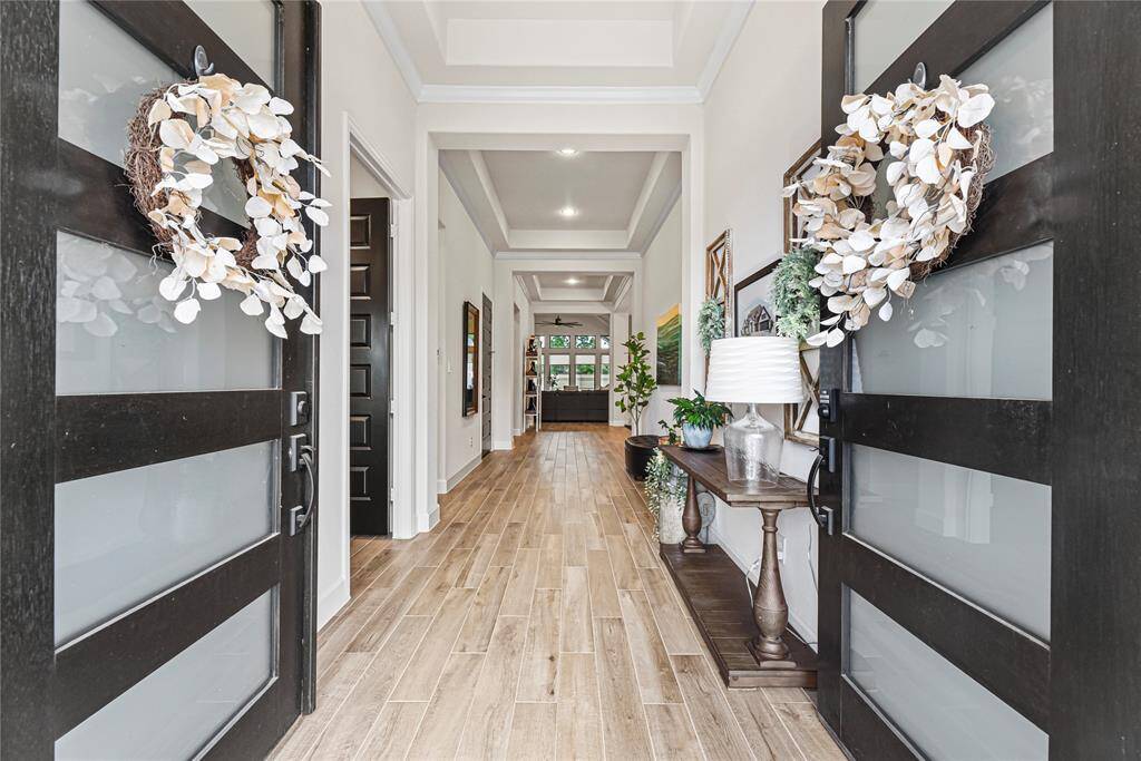 This show stopping open-concept living area features soaring vaulted ceilings, abundant natural light from a wall of windows and seamless flow into a chef-inspired kitchen with custom cabinetry and designer lighting.