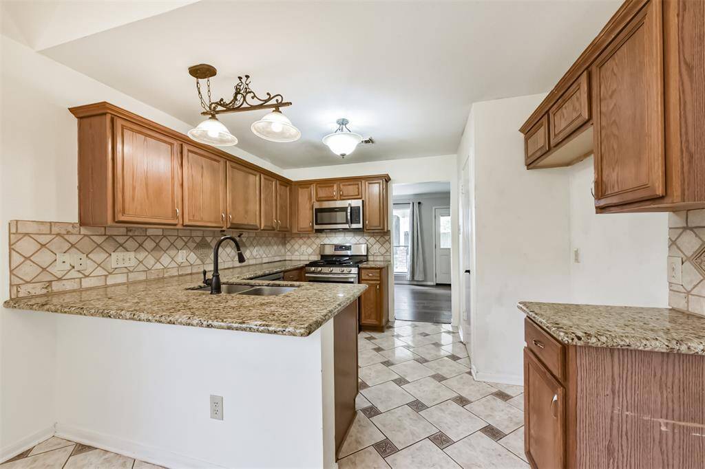 Rich wood cabinets pair beautifully with granite countertops for a timeless look.