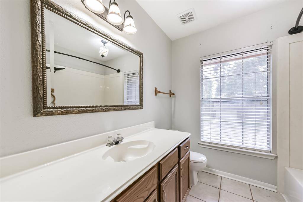 Upstairs full bath features a single vanity and a shower/tub combo