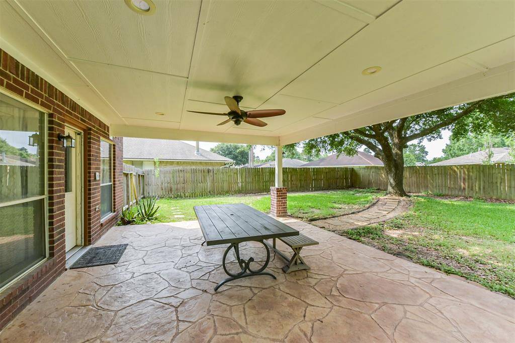 Enjoy a shaded retreat under the covered patio with a ceiling fan and picnic table.