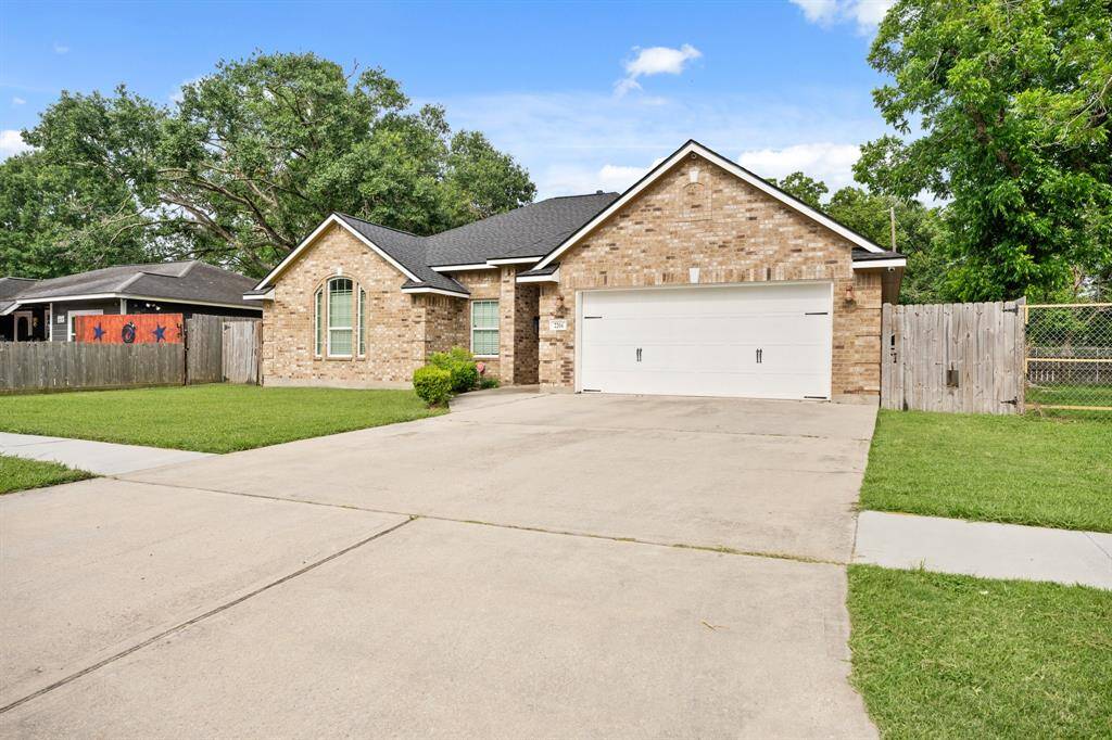 Charming brick home with a spacious driveway and two-car garage. It features a well-maintained lawn, fenced backyard, and mature trees, offering great curb appeal in a peaceful neighborhood.