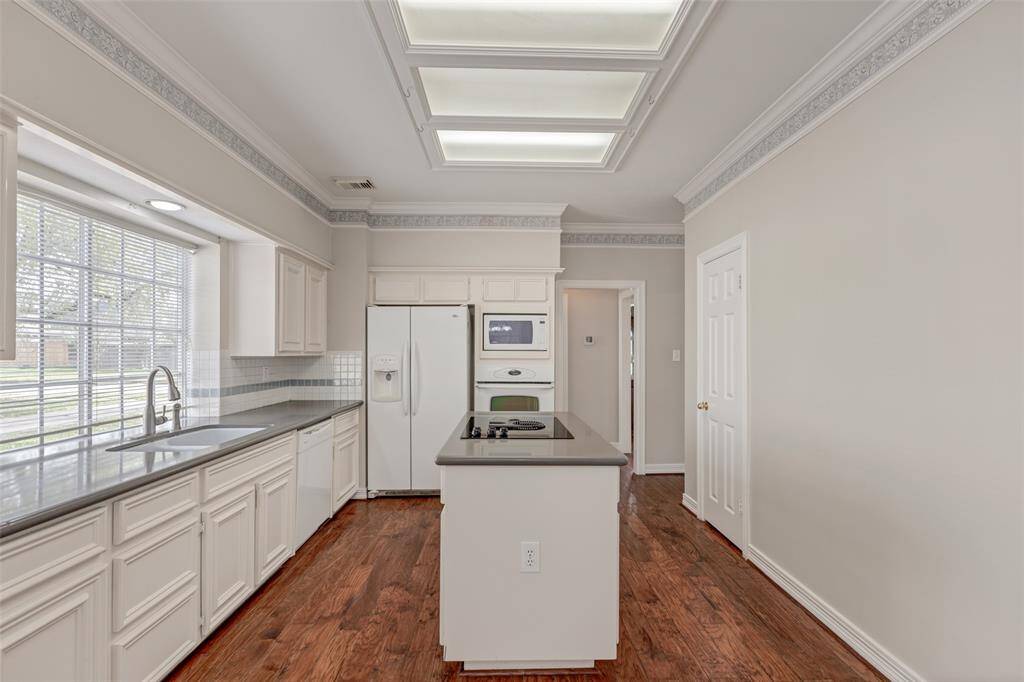 The extra wide window at the sink provides a view to the side and partial front while allowing for beautiful natural lighting to stream into the kitchen. Just through the open door way is the laundry room and powder room.