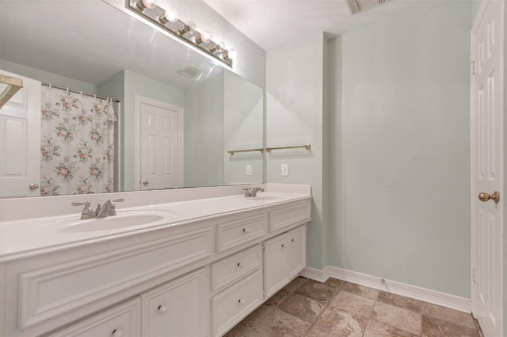 This ample full bath includes a double bowl vanity with plenty of storage, a shower/tub combination, and water closet with additional storage.