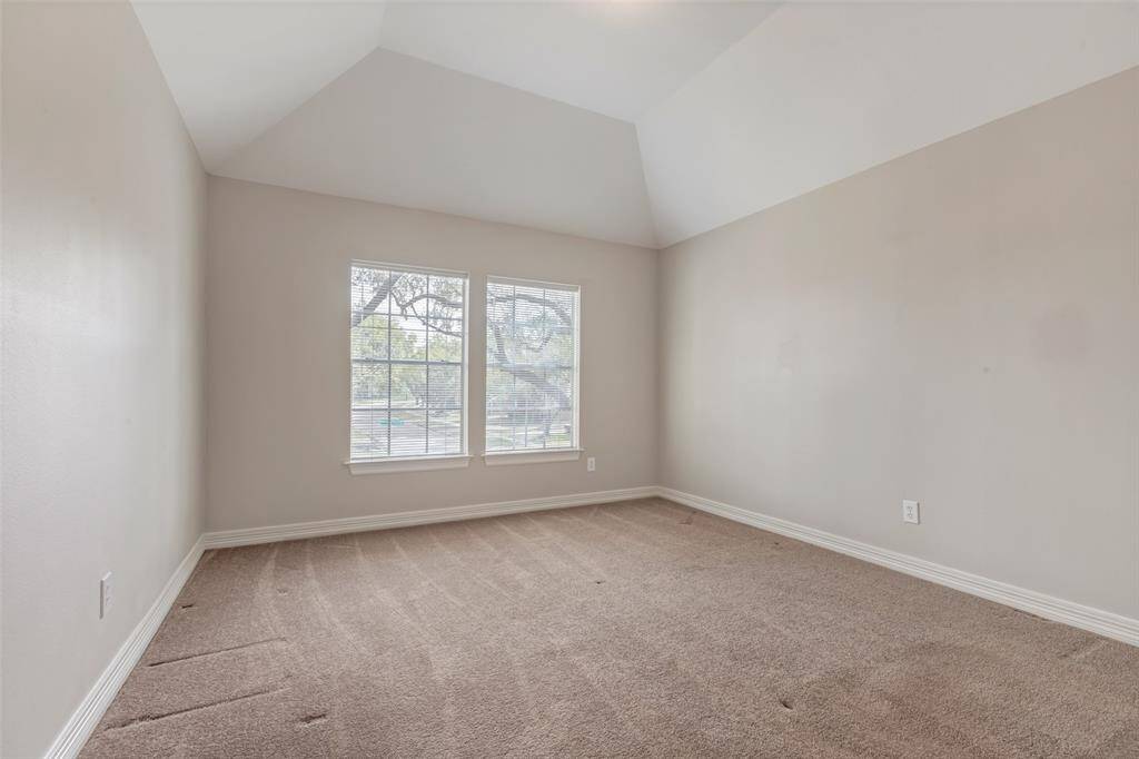 The third secondary bedroom overlooking the front lawn. All of the bedrooms feature windows dressed in blinds.