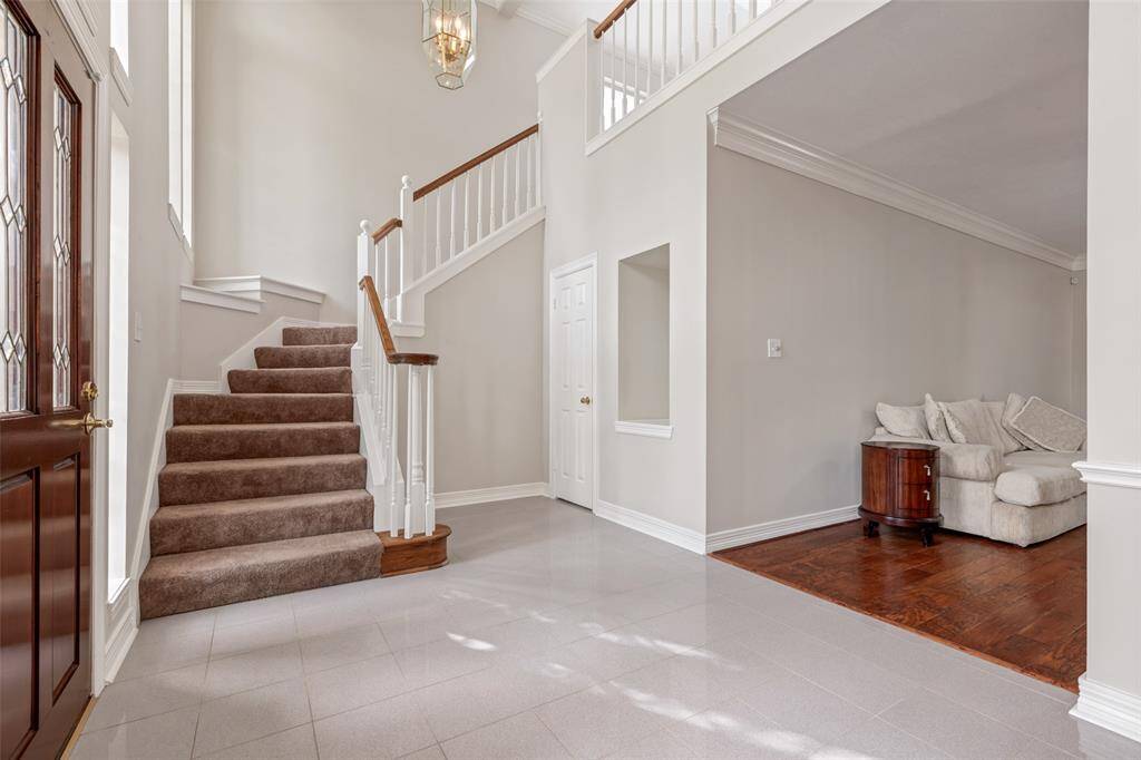 The elegant two-story tiled entry is filled with natural lighting illuminating the curved staircase leading to the second floor. Notice the recessed niche designed for your favorite art piece.