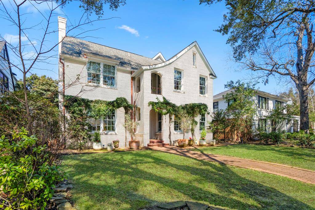 The lush landscape and brick-paved path create a picture-perfect entrance to this elegant home. Mature trees frame the exterior offering timeless curb appeal while the Tudor swoop roofline adds a touch of storybook charm, setting the stage for an inviting retreat.
