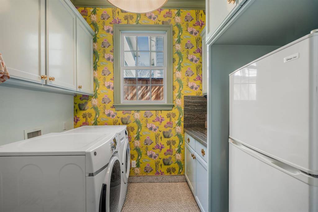 A laundry room that turns chores into a delight, featuring vibrant wallpaper and built-in cabinetry. Thoughtfully designed to brighten your day, this space makes organization feel luxurious.