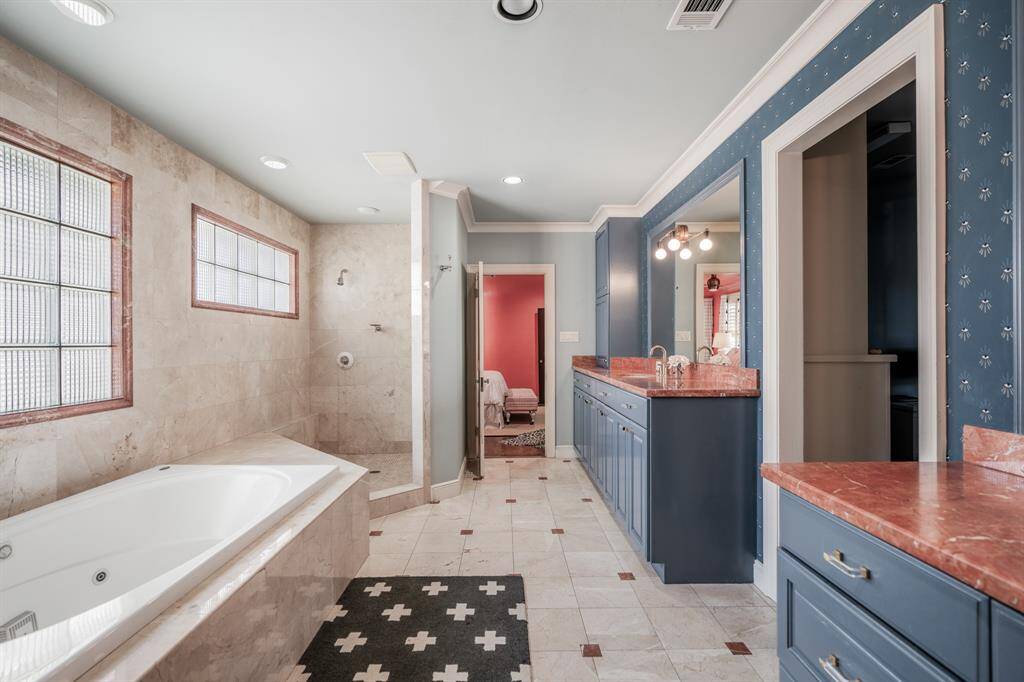 The oversized jetted tub invites relaxation, perfect for unwinding after a long day, while the spacious walk-in shower offers both style and comfort, completing this spa-like retreat. The expansive walk-in closet is a dream with a generous amount of space, perfect for two.