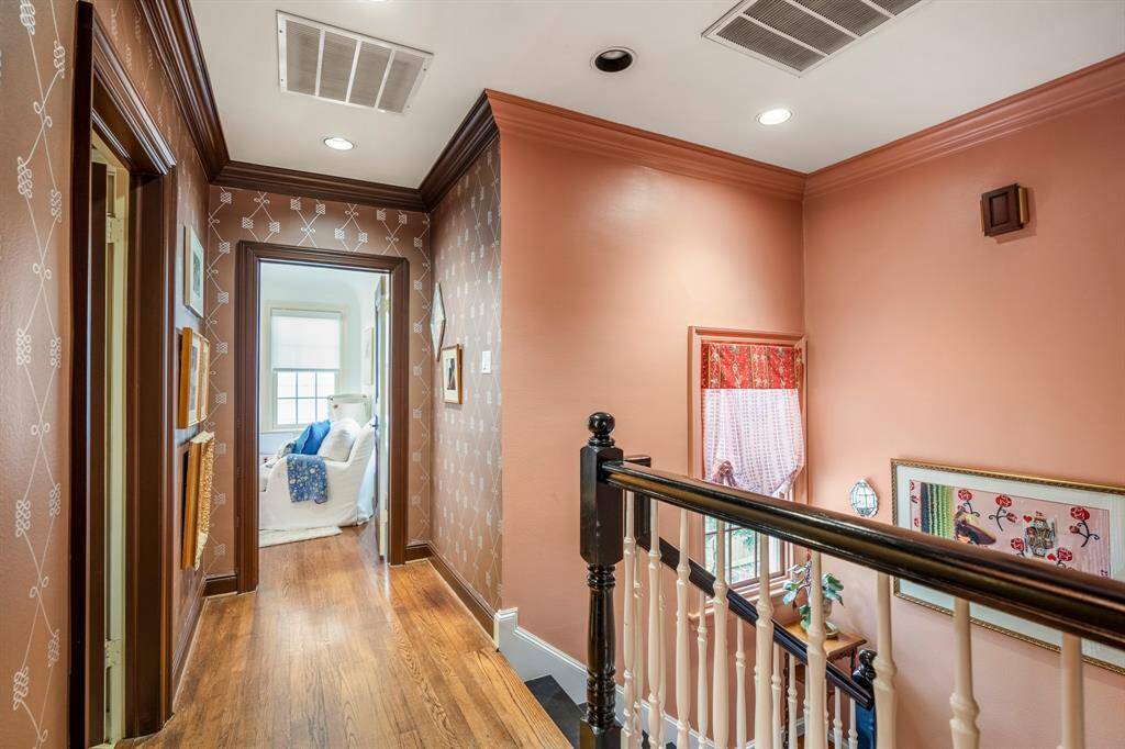 The Schumacher wallpaper-adorned walls lead you down the hallway to the secondary bedrooms.