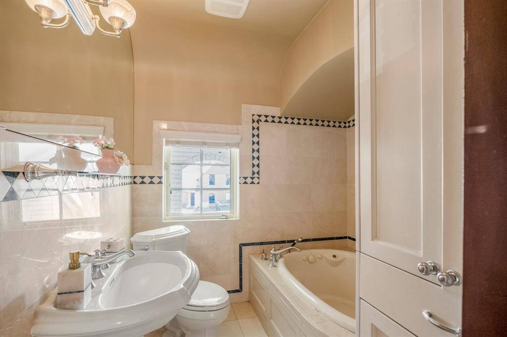 The shared upstairs bath retains its original charm, blending vintage elegance with modern comfort. Classic details and fresh updates create a timeless space for family and guests alike.