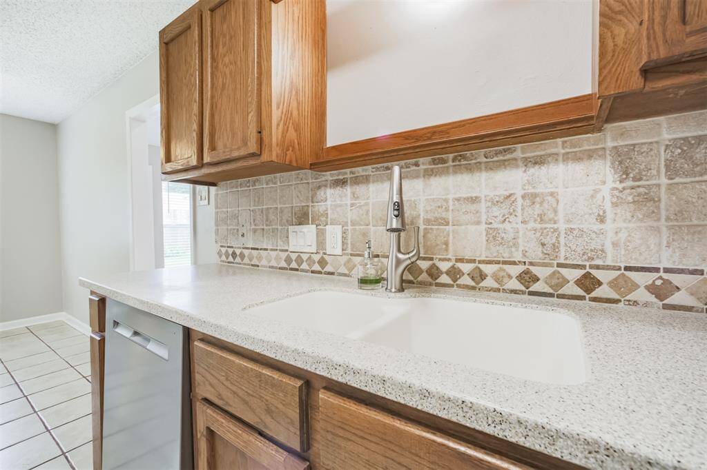 Mosaic backsplash accents the corian countertops.