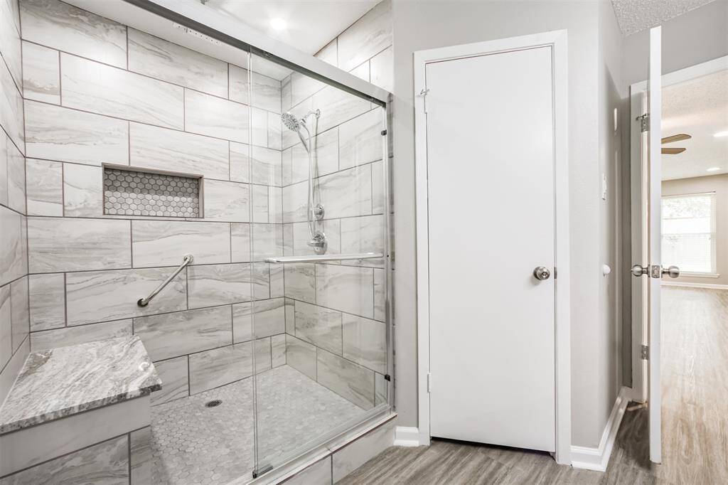 Look at this gorgeous shower! Mosaic tile floor, niche, seat, glass enclosure!