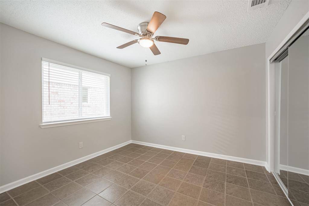 2nd bedroom with tile floors and updated ceiling fan.