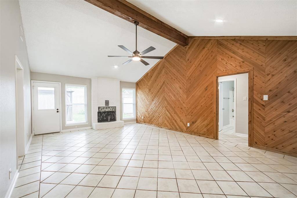 Main living with neutral ceramic tile, fresh paint (even the ceilings), funky wood accent wall, updated ceiling fan, wood burning fireplace. NOTE: newly installed recessed lighting! Spacious and ready for your imagination to fill it!