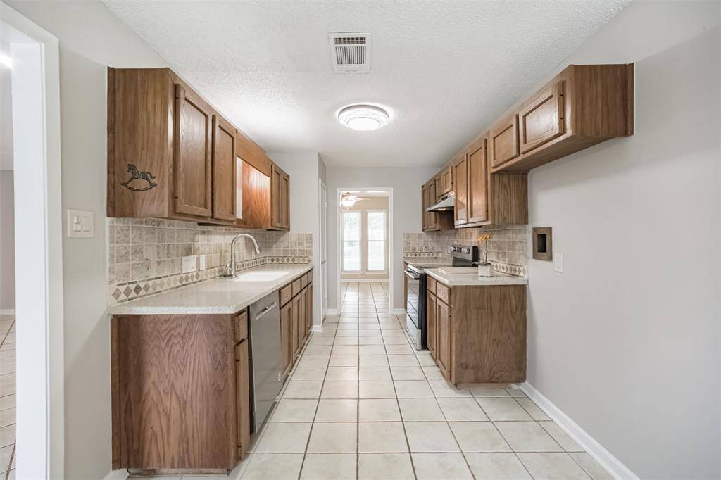 Galley kitchen with plenty of counter and cabinet space! Solid surface corian counters. Even the lighting has been updated!