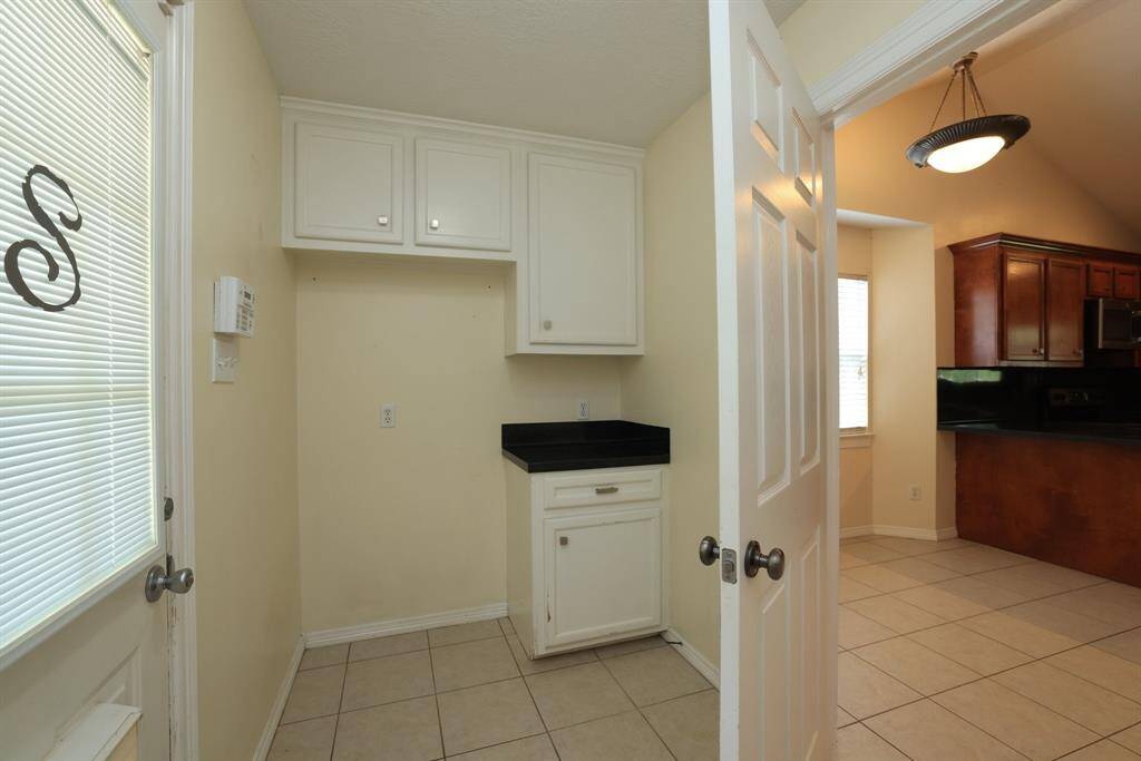 This cozy primary room features warm-toned walls, concrete floor, and a ceiling fan with light. It has a large window that brings the natural light and offers a welcoming atmosphere.