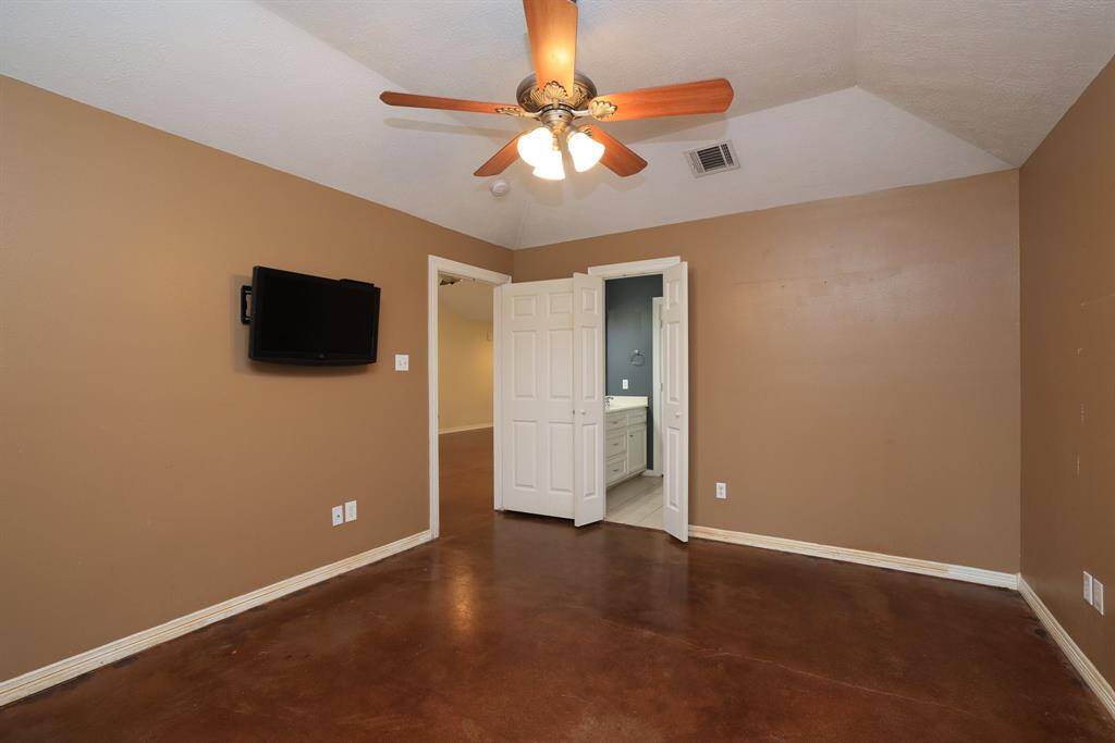 This bathroom features a glass-enclosed shower, a corner bathtub, and tile flooring. It includes recessed lighting and shelving for convenience.