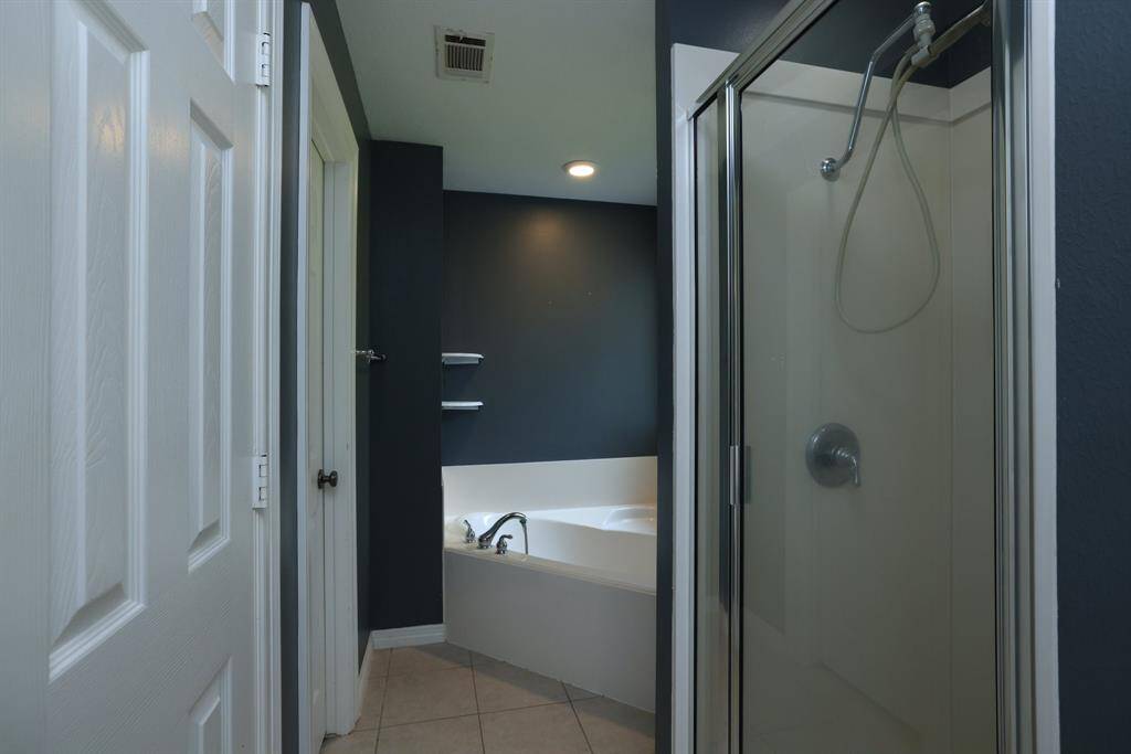 This photo shows a walk-in closet with ample storage space, featuring multiple shelves and hanging rods, perfect for organizing clothes and accessories.