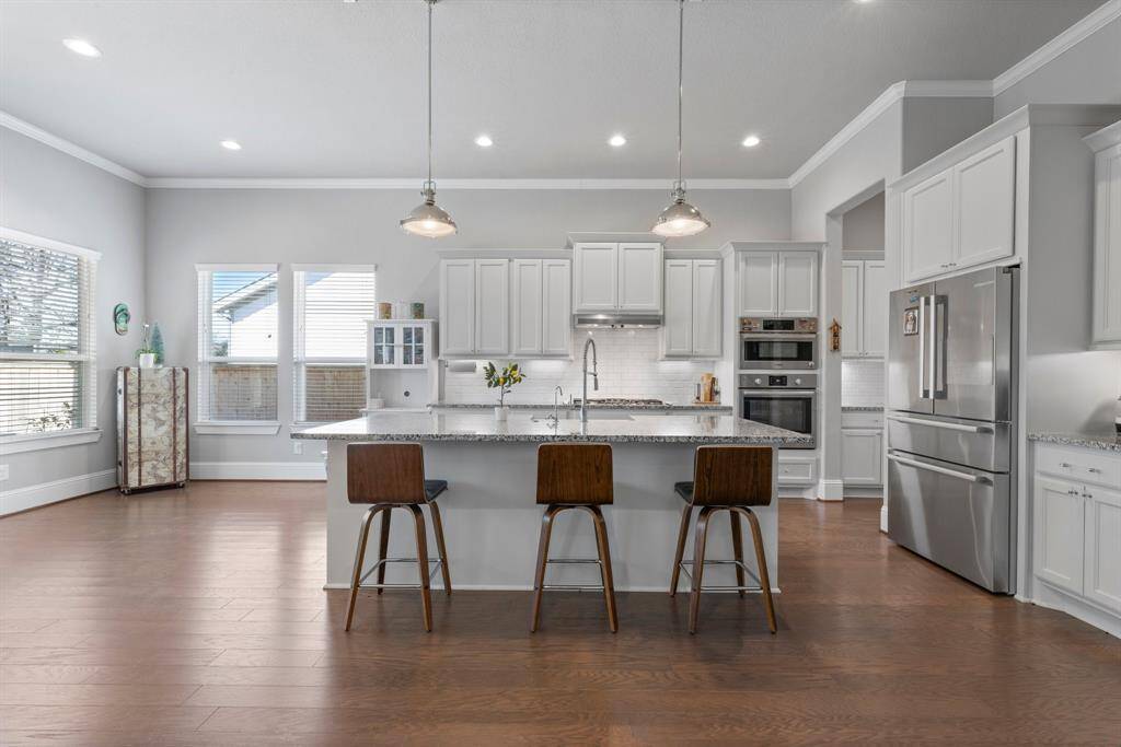 Kitchen with tons of cabinets and a large island. Fridge included.