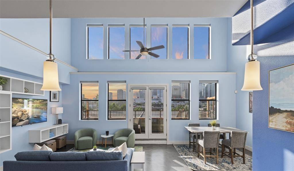 Entertain with ease in this open concept living and dining area. Floor to ceiling glass with hidden automatic shades installed on all windows