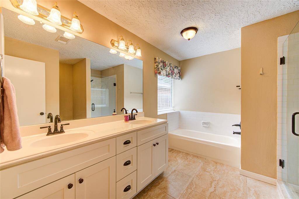 Updated primary bath with recent vanity, soaking tub, and walk-in shower!