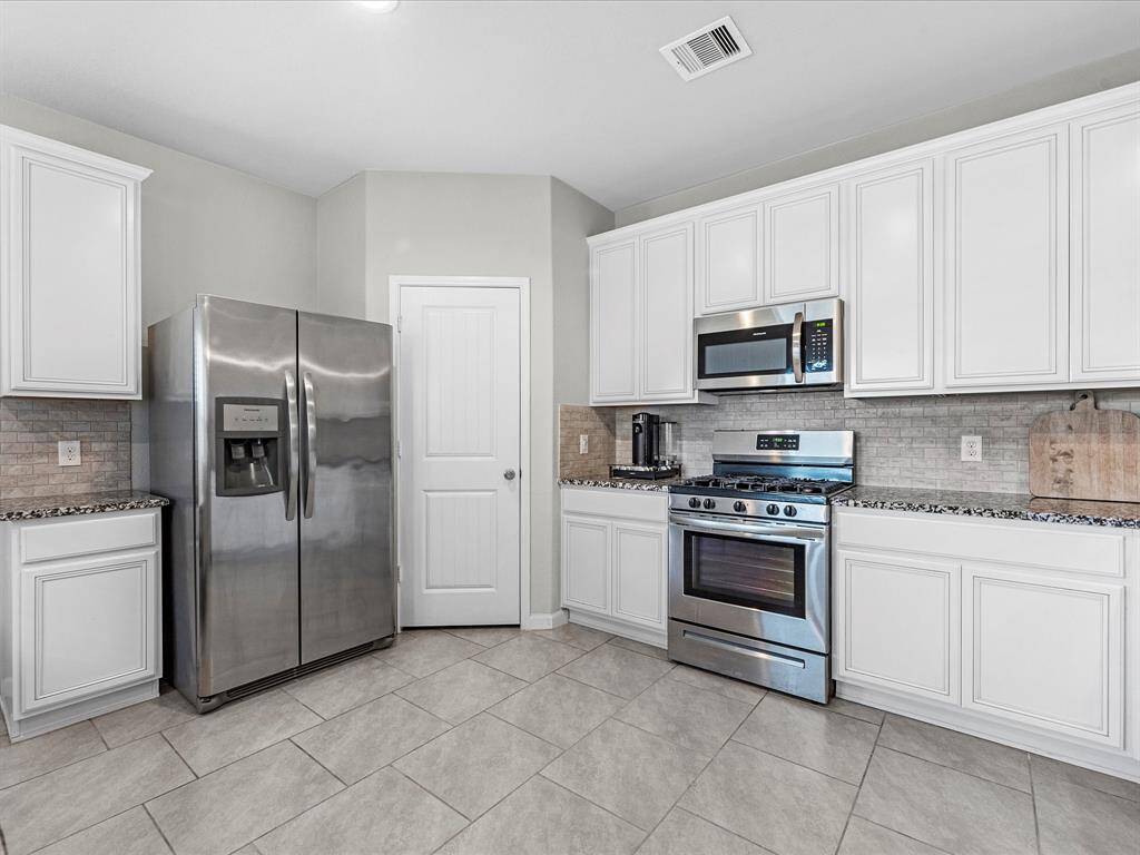 Amazing kitchen featuring granite counter tops, gas stove, fridge included, and tons of seating space