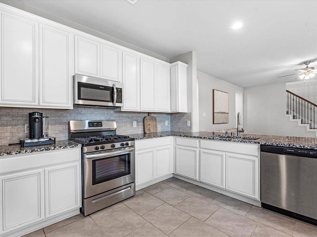 Amazing kitchen featuring granite counter tops, gas stove, fridge included, and tons of seating space