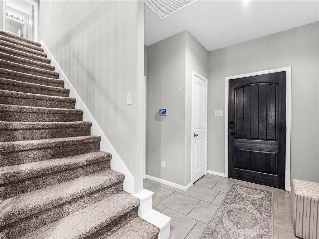 The first floor features tile flooring throughout the entertainment area, with an amazing open concept floorplan and the perfect space to host. Notice the amazing details like the iron stair railing and hard wood front door.