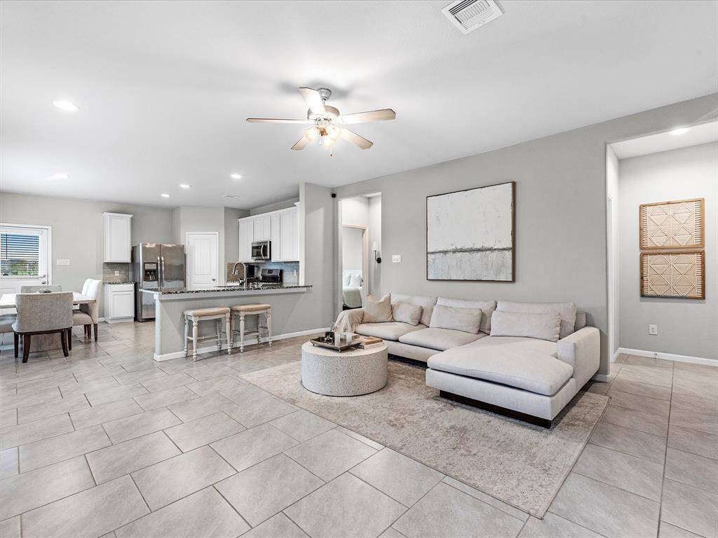 The first floor features tile flooring throughout the entertainment area, with an amazing open concept floorplan and the perfect space to host. Notice the amazing details like the iron stair railing and hard wood front door.