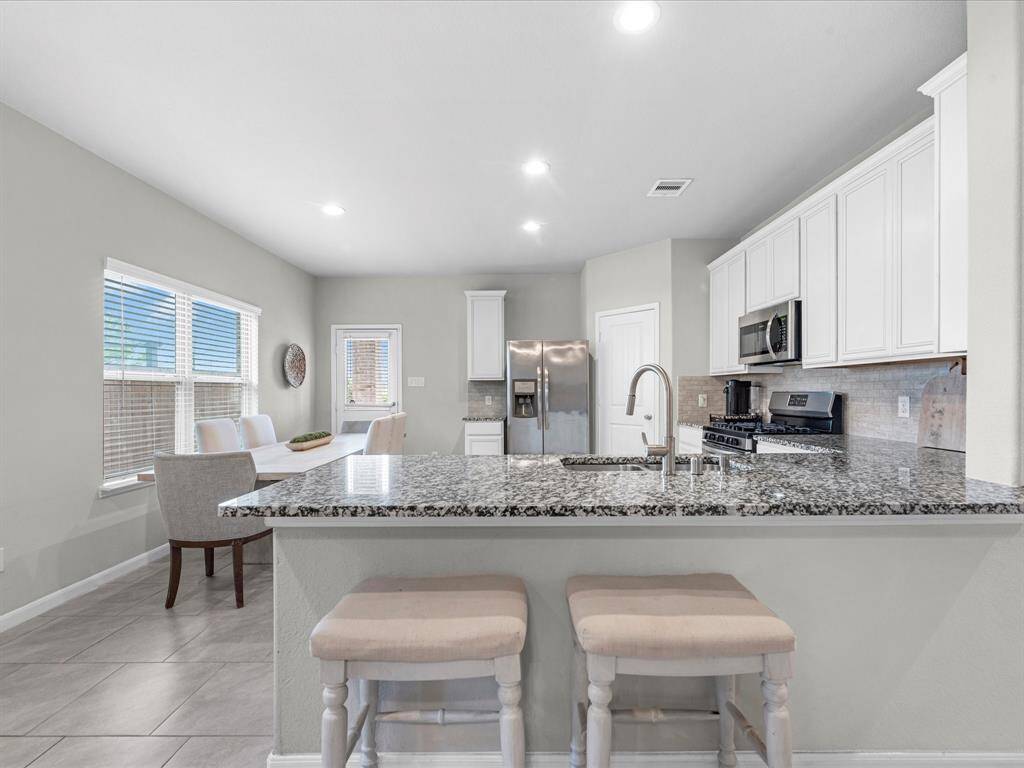 Amazing kitchen featuring granite counter tops, gas stove, fridge included, and tons of seating space.