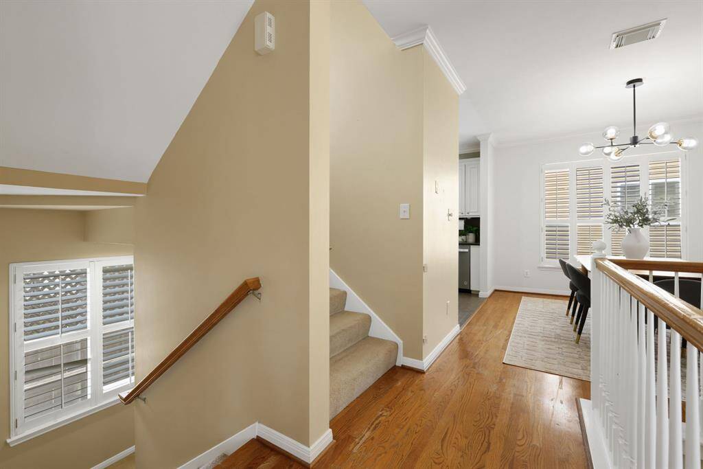 A transitional vantage point showing the flow from stairway to open-concept dining and kitchen areas—light, bright and inviting