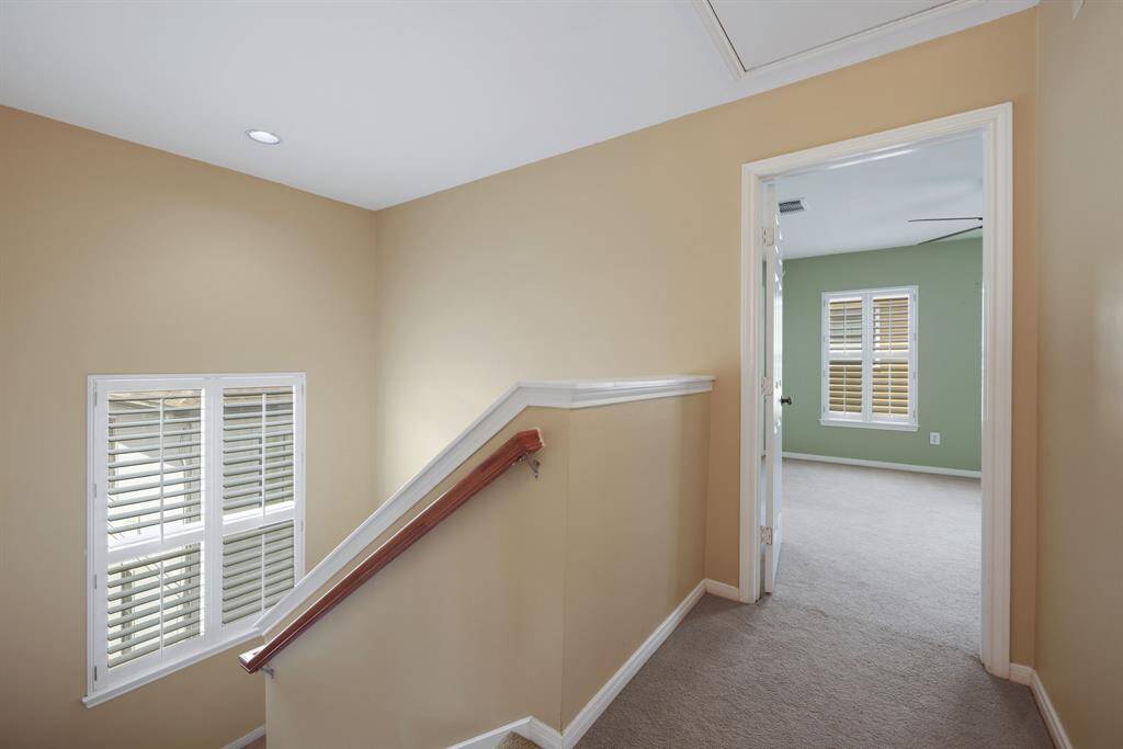 At the top of the stairs, this landing leads to the serene primary suite, thoughtfully separated for privacy