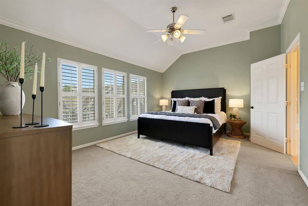 Step into the serene primary suite, where windows bathe the room in soft light and offer peaceful views