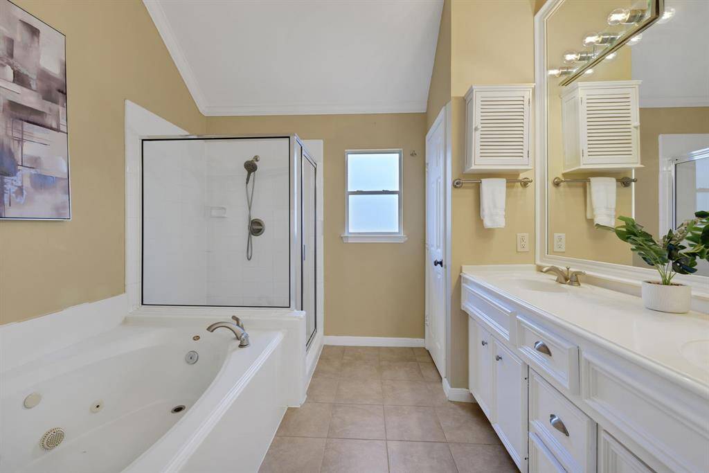 An elegant primary bath with dual vanities, a soaking tub and a walk-in shower designed for daily luxury