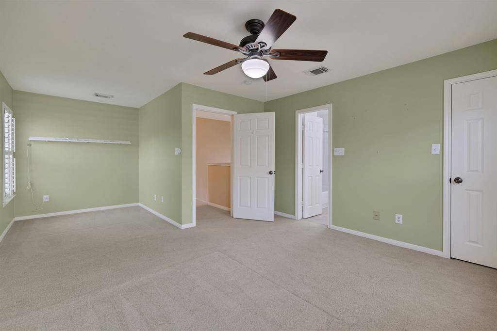 Spacious secondary bedroom with clean lines, neutral tones and ample natural light