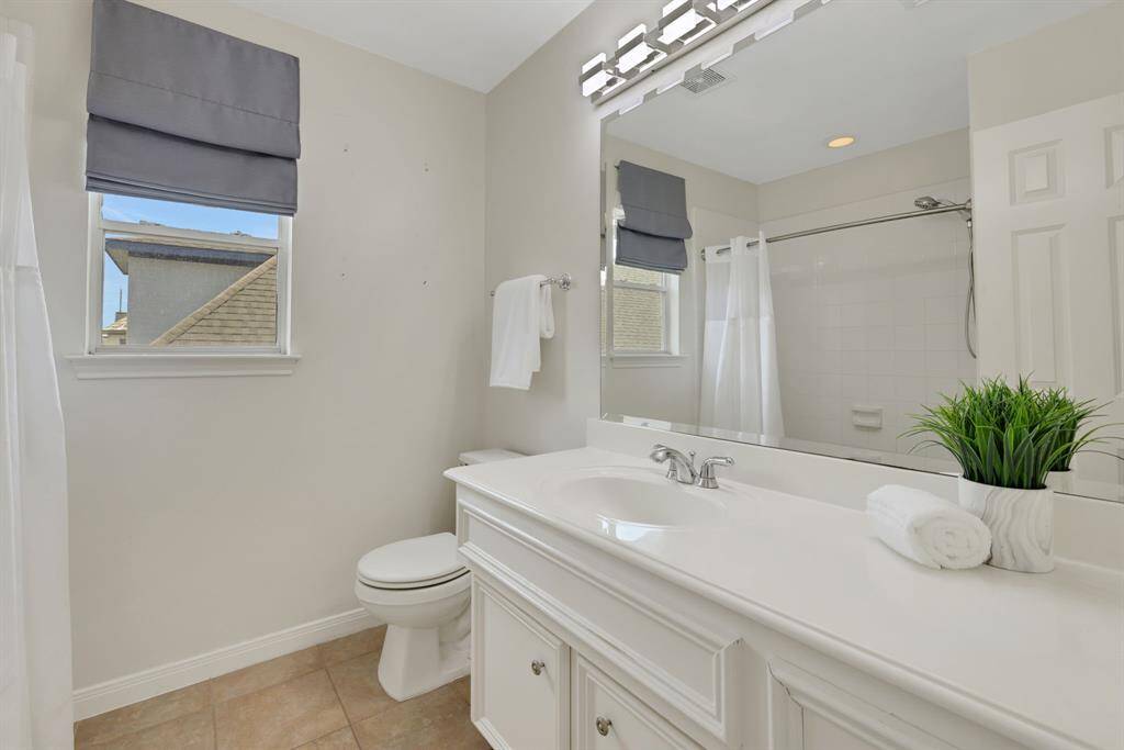 A well-appointed second full bath with modern fixtures and sleek design