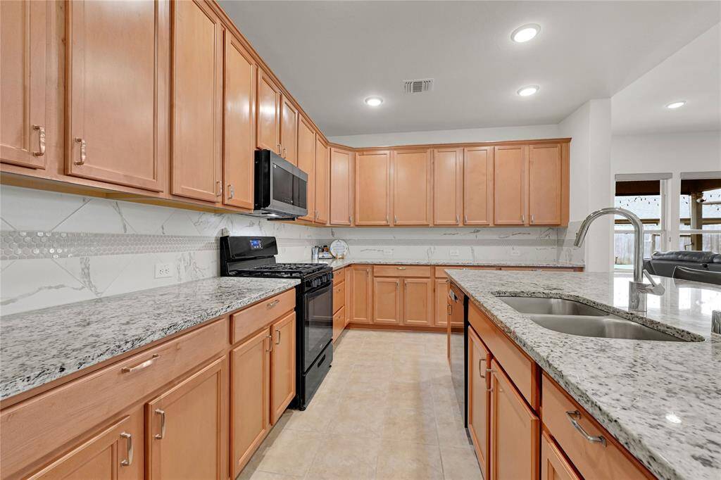 Chef’s Dream Kitchen – Ample cabinetry, gleaming granite countertops, and a large island with breakfast seating