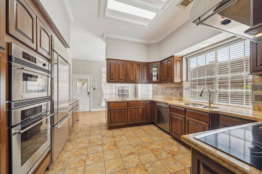 Premium stainless steel appliances, including a built-in oven and electric cooktop, make this kitchen both stylish and highly functional for everyday cooking.