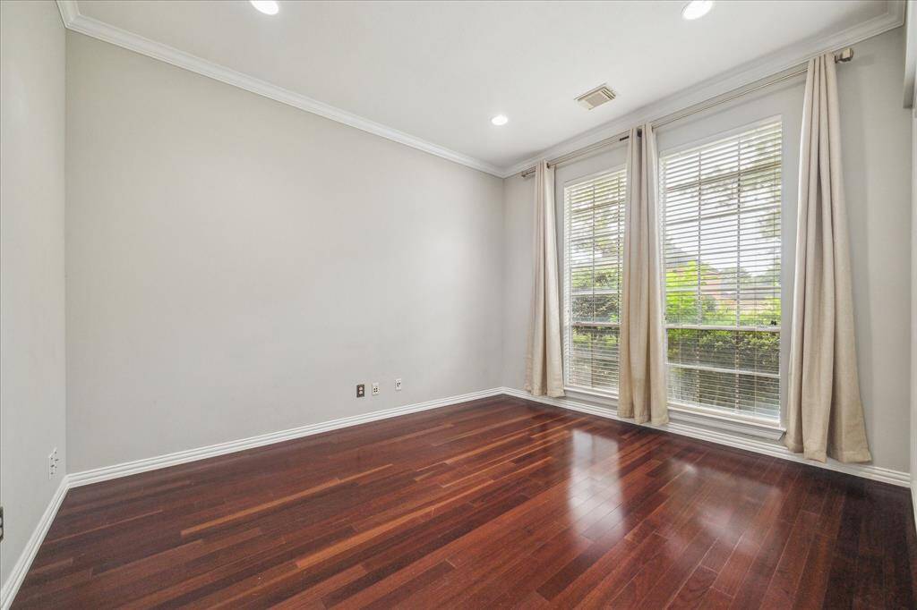 Tucked just off the living room and primary bedroom, this dedicated home office offers quiet seclusion with abundant natural light and classic crown molding.
