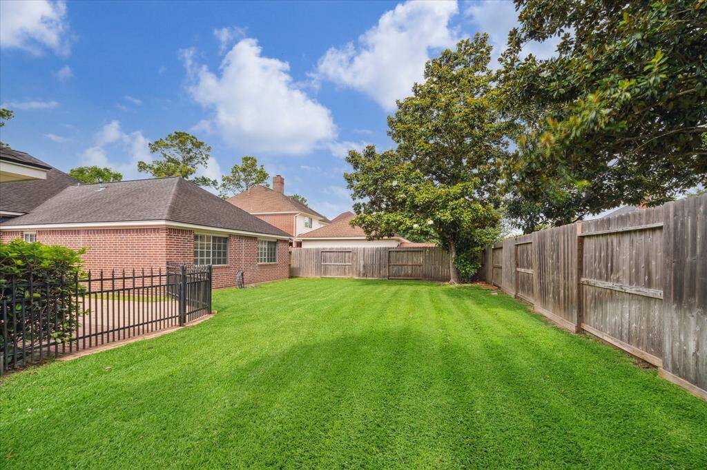 Mature trees line the back fence, creating privacy and shade in this inviting outdoor retreat.