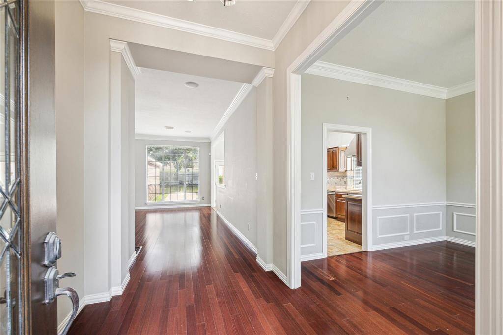 From the moment you step inside, you're greeted by gleaming wood floors, elegant crown molding, and a bright open layout with sightlines straight to the backyard.