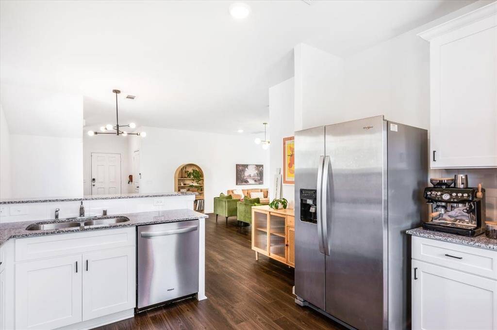 Kitchen features granite countertops , beautiful white cabinets with updates hardware, stainless appliances, large sink and natural light.