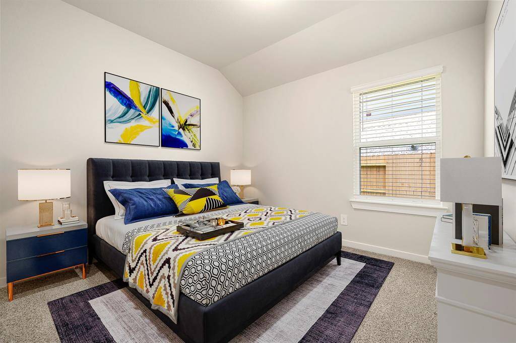 This cozy bedroom offers a soft, neutral palette and generous natural light through large double windows. The elevated ceiling enhances the sense of openness, while the plush carpeting adds warmth and comfort to the space.